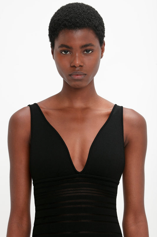 A woman in a black Victoria Beckham Frame Detail Sleeveless Dress.