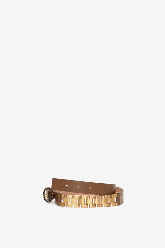 Victoria Beckham Watch Strap Detail Belt in Khaki-Brown with a gold-tone metallic buckle and linked details, displayed against a plain white background.