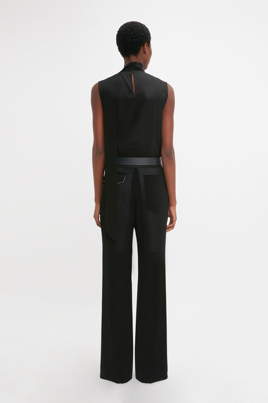 Back view of a person wearing a Victoria Beckham modern black sleeveless top and Victoria Beckham featherweight wool straight leg trousers, standing against a plain white background.