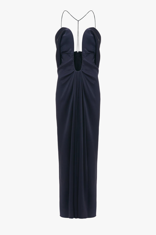Navy blue evening gown with a sweetheart neckline and Victoria Beckham Frame Detail Cut-Out Cami Dress straps, featuring a cinched waist and draped skirt.