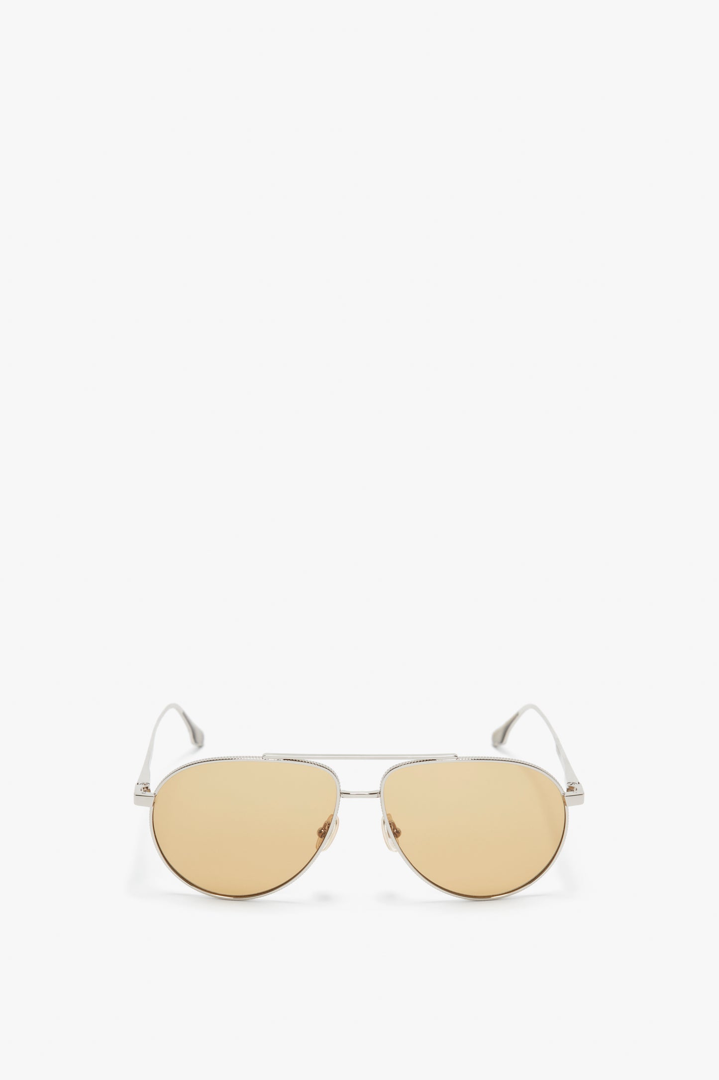 A pair of Victoria Beckham aviator sunglasses with thin metal frames and light amber-tinted lenses, featuring adjustable nose pads, isolated on a white background.