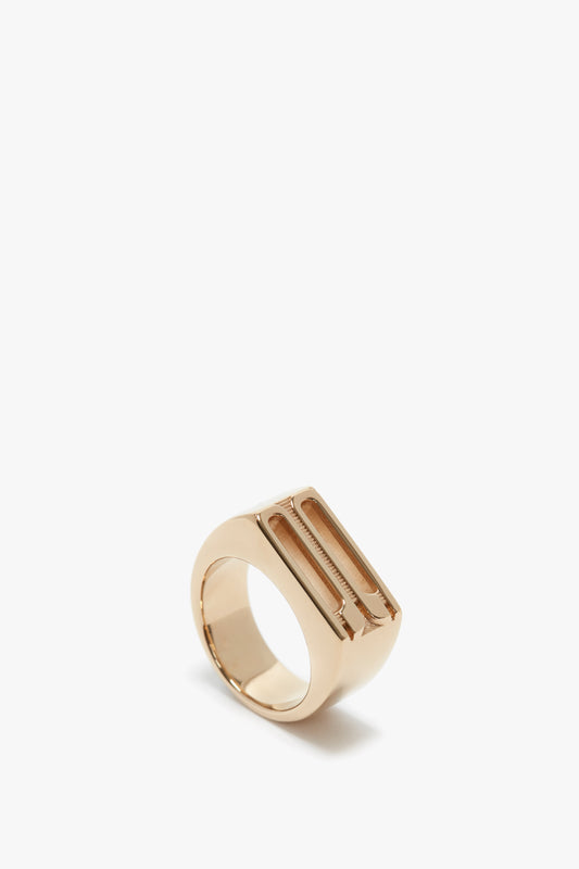 A polished gold-coated brass Exclusive Frame Signet Ring in Gold with a wide band and a slot detail, isolated on a white background by Victoria Beckham.
