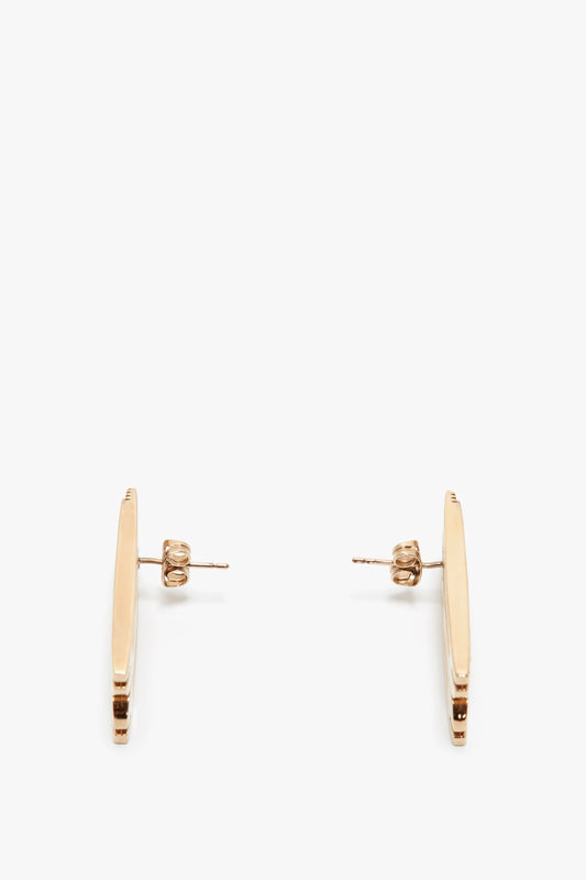A pair of Victoria Beckham Exclusive Frame Stud Earrings In Gold displayed on a white background.