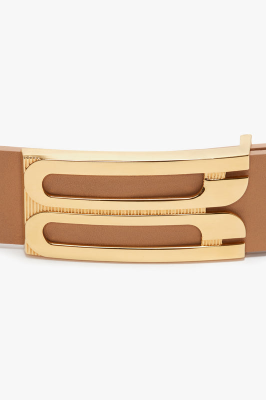Close-up of a Jumbo Frame Belt In Camel Leather by Victoria Beckham featuring a unique gold buckle with a zipper-like design.