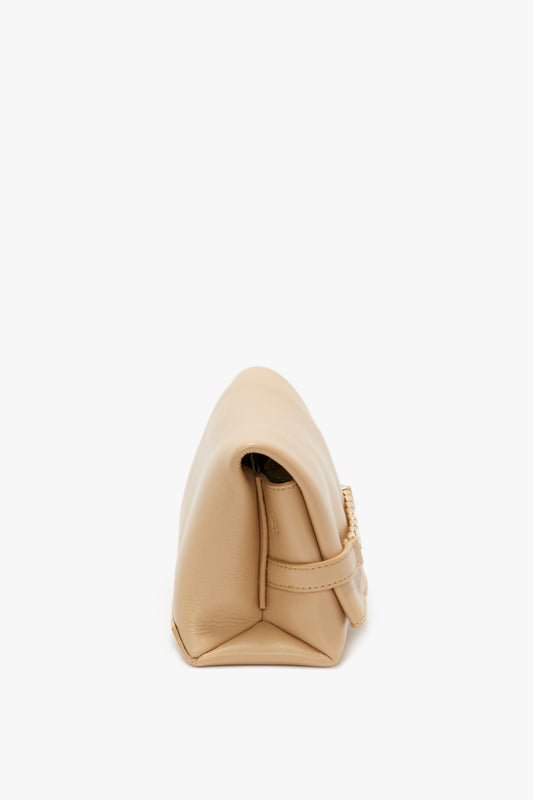 A Mini Pouch With Long Strap In Sesame Leather by Victoria Beckham resting on its side on a white background.