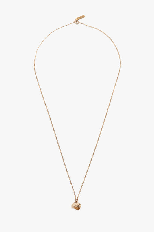 A thin Exclusive Camellia Flower Necklace In Gold, handcrafted in Italy by Victoria Beckham, featuring a small, irregularly shaped pendant on a white background.