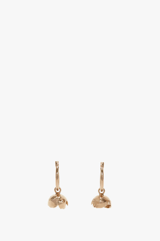 A pair of Exclusive Camellia Flower Hoop Earrings In Gold by Victoria Beckham with a pin closure, isolated on a white background.