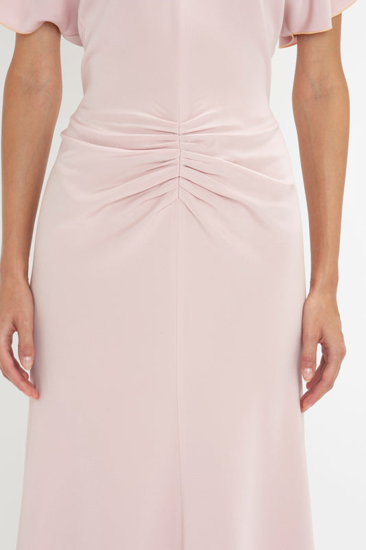 A close up of a woman's body in a Victoria Beckham Gathered Waist Midi Dress In Blush.