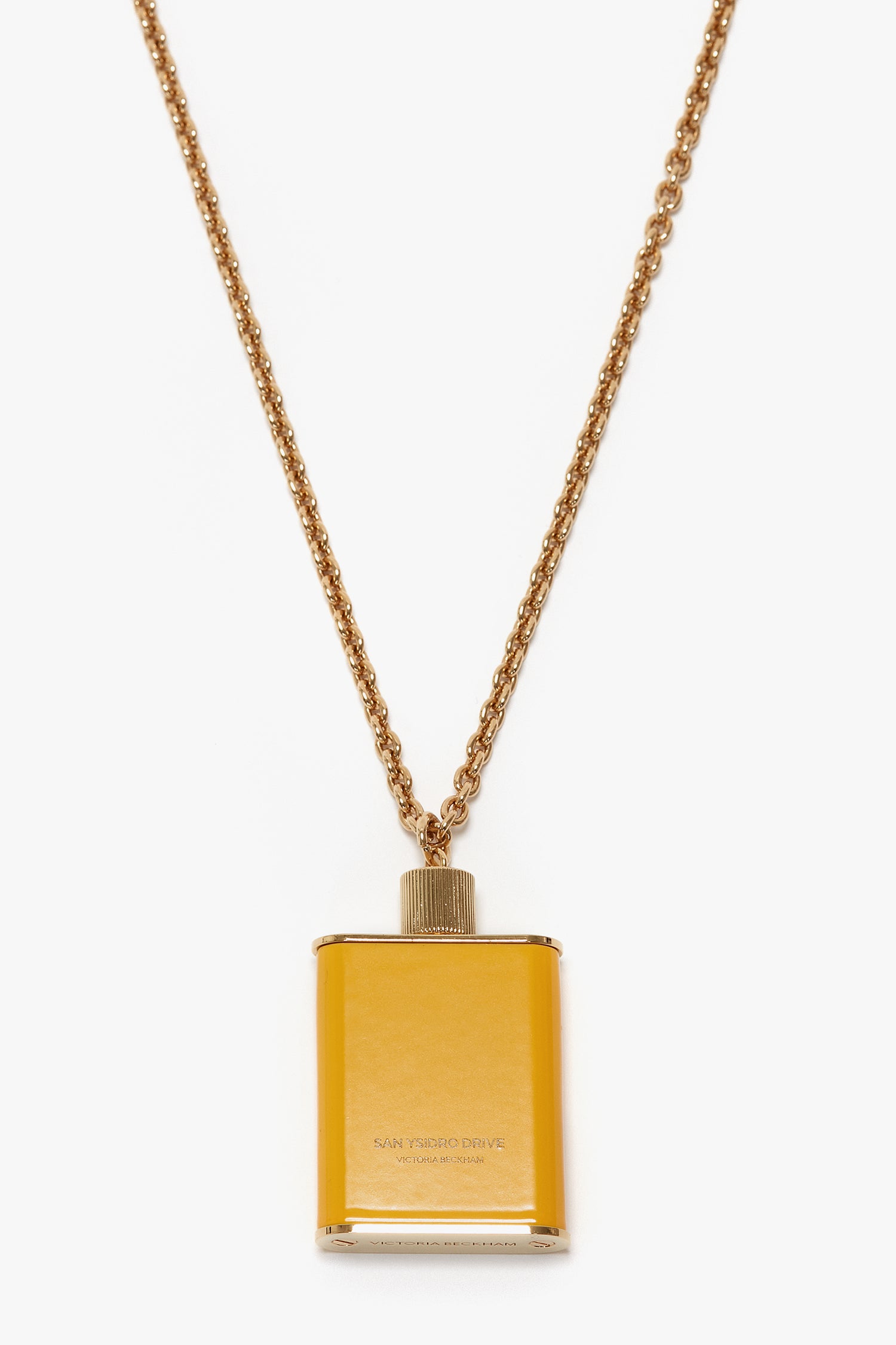 Perfume Bottle Necklace In San Ysidro Drive with a rectangular pendant designed to resemble a flask, featuring gold brushed brass finish and subtle Victoria Beckham branding.