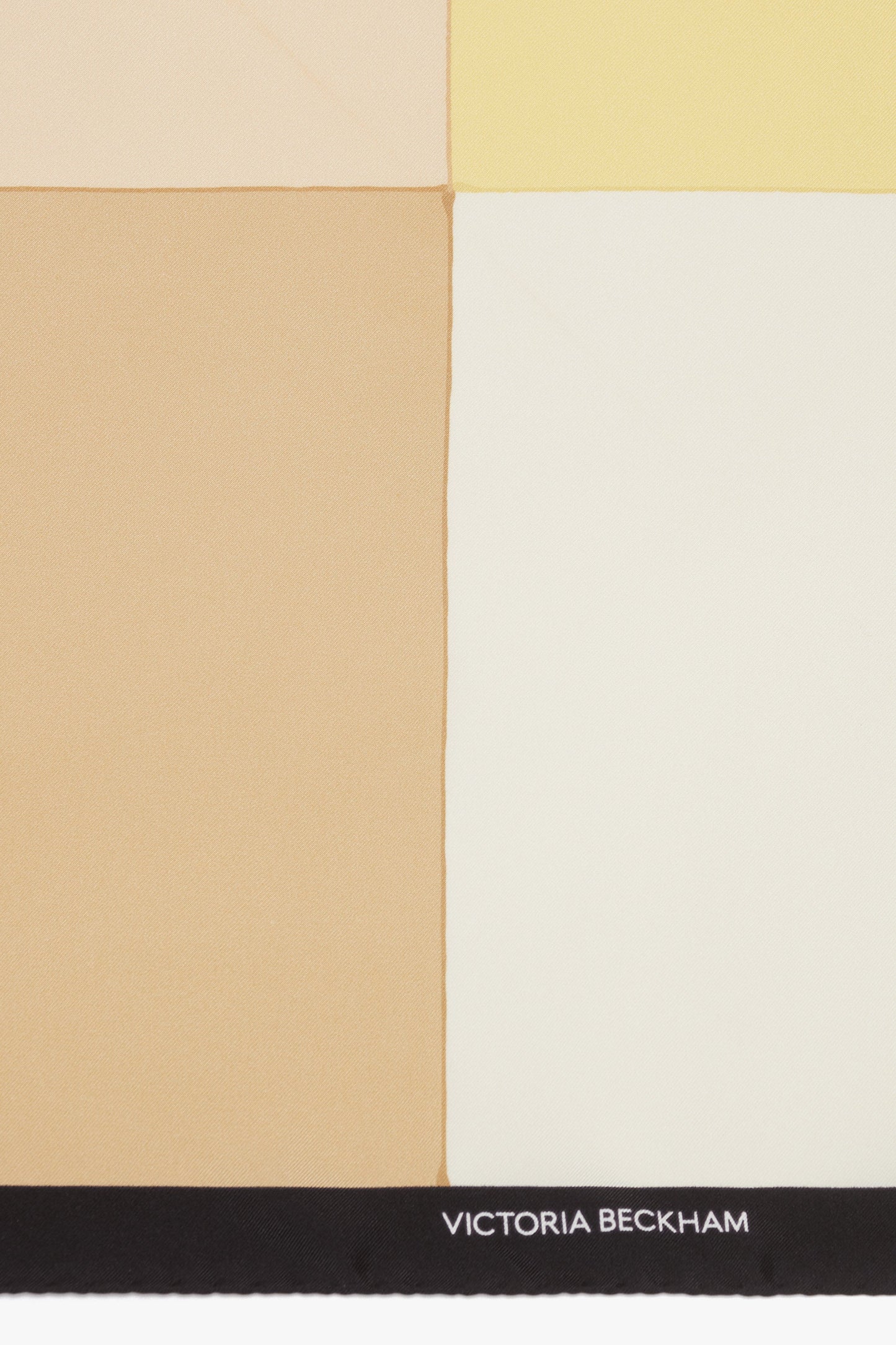 A sophisticated accessory, the Victoria Beckham Colour Block Silk Scarf In Macadamia features a color-blocked design with beige, tan, light yellow, and cream sections adorned with "Victoria Beckham" in white on a black border.