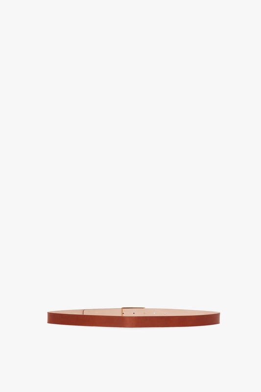 Exclusive Frame Buckle Belt In Tan Leather by Victoria Beckham, isolated on a white background.