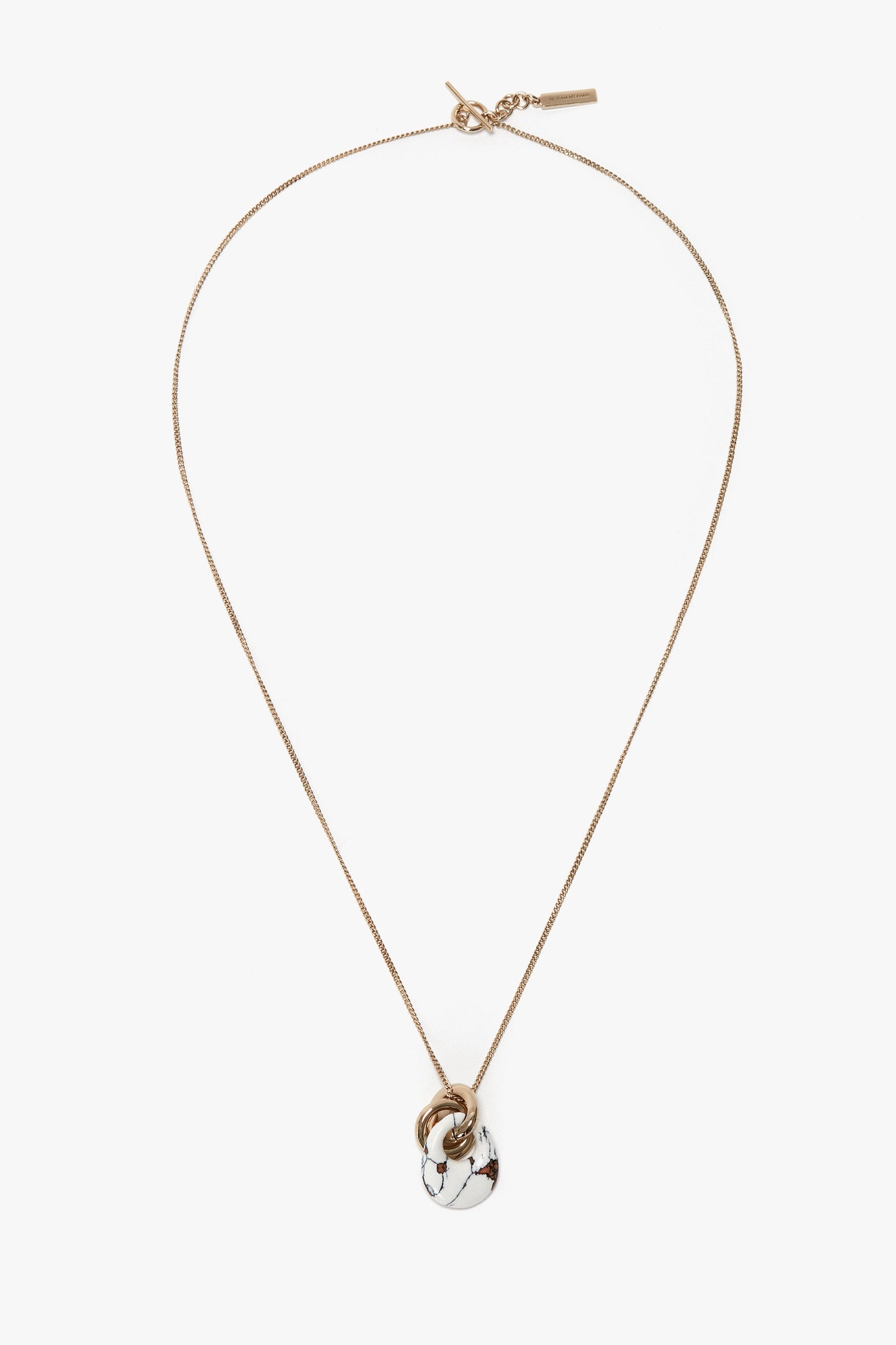 A Victoria Beckham Exclusive Resin Pendant Necklace In Light Gold-White with a marble-patterned circular resin pendant and gold accent ring on a white background, made from 100% brass.