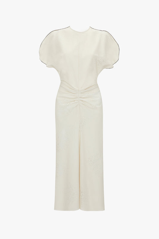 An elegant white dress featuring short puffed sleeves, a Gathered Waist Midi Dress In Cream and a subtle floral pattern by Victoria Beckham.