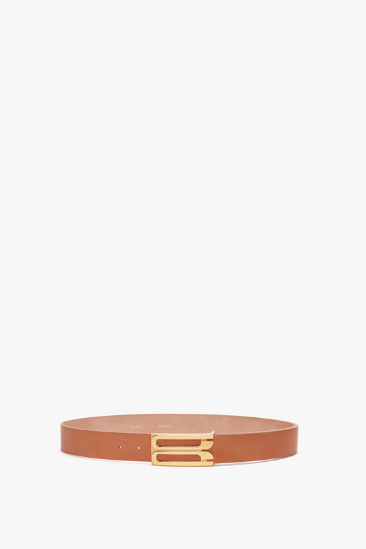 A slim, tan Victoria Beckham calf leather belt with a golden buckle, displayed against a white background.