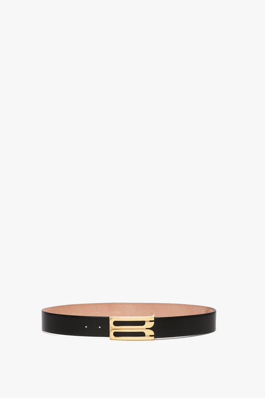 A Exclusive Jumbo Frame Belt in black leather with a minimalist gold buckle by Victoria Beckham on a white background.