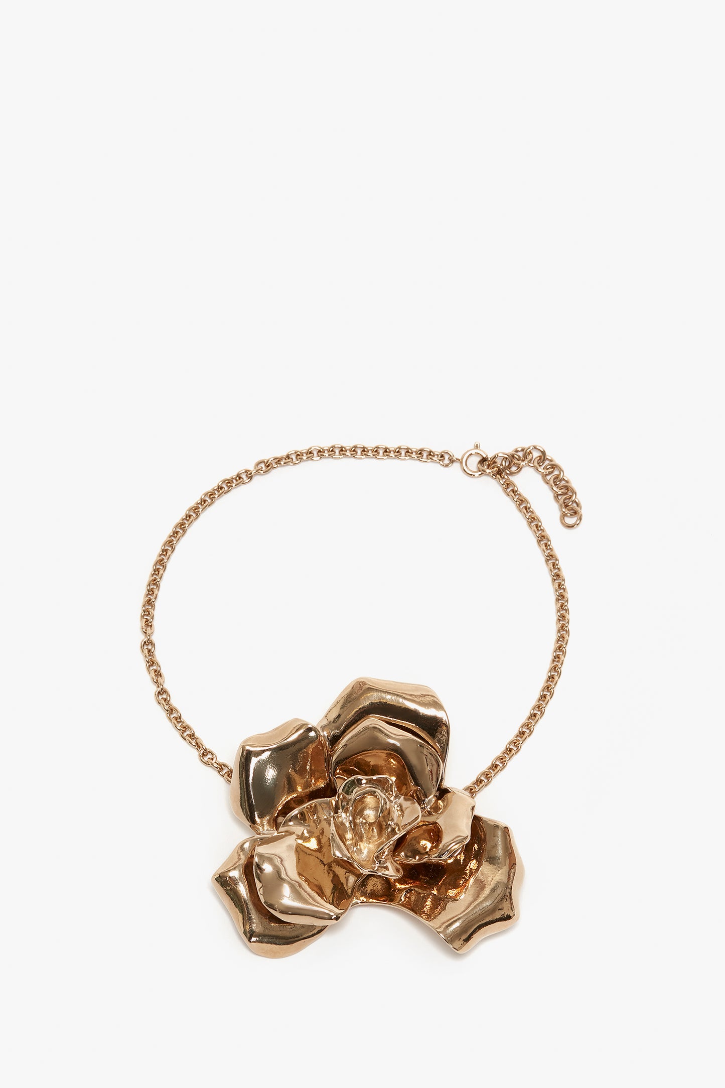 The Victoria Beckham Exclusive Flower Necklace In Gold features a large, detailed rose design as the central pendant, made from gold brushed brass for a refined touch.