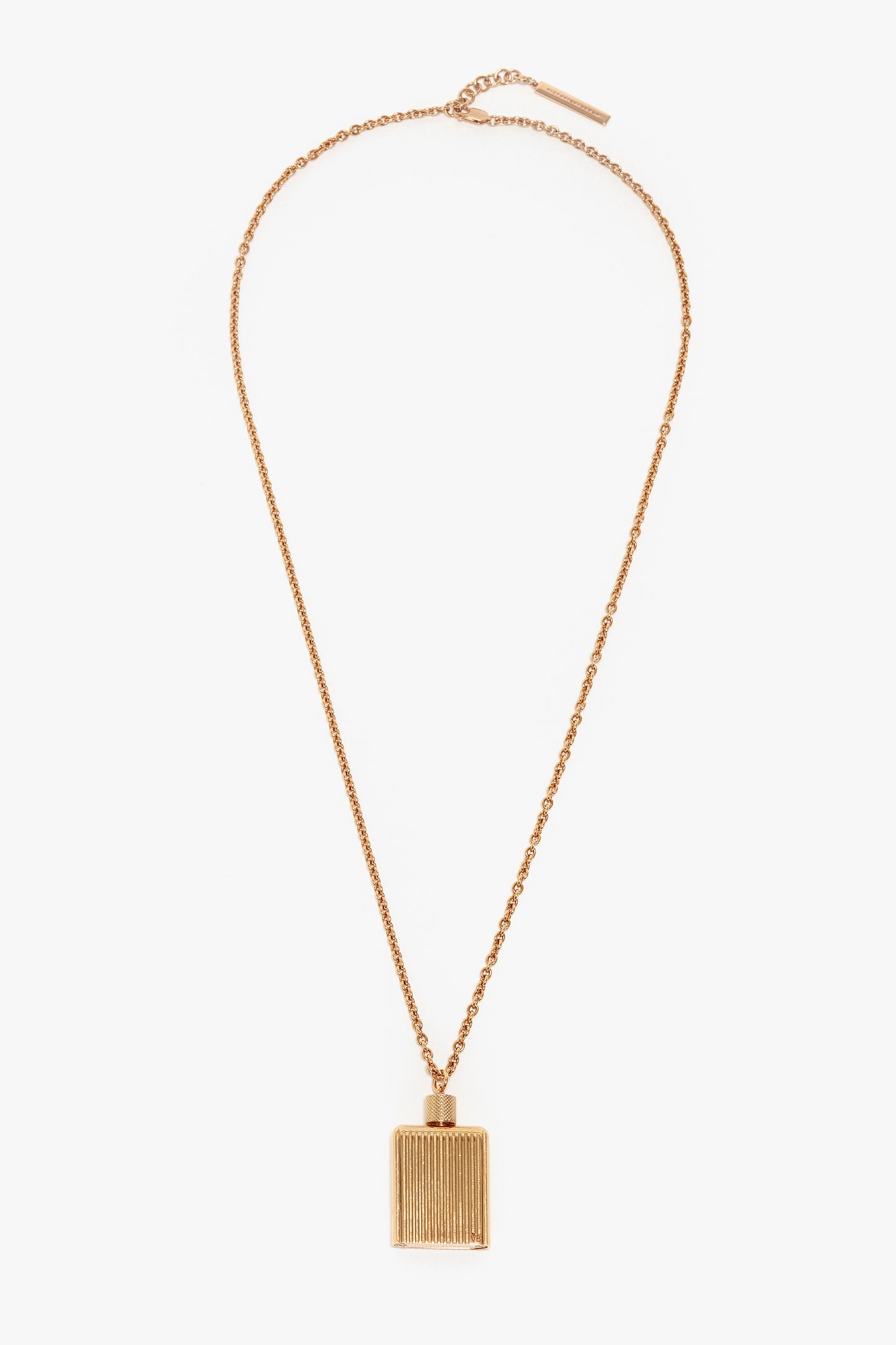 A gold brushed brass chain necklace with a rectangular pendant featuring vertical grooves, reminiscent of the elegance found in Victoria Beckham Exclusive Perfume Bottle Necklace In Brushed Gold.