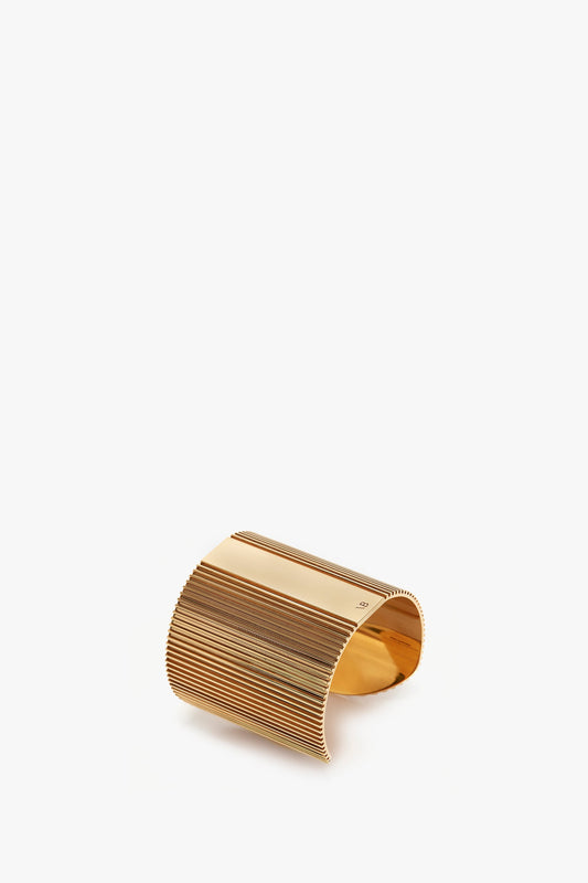 Victoria Beckham's Exclusive Perfume Cuff In Gold with a ribbed design on a white background.