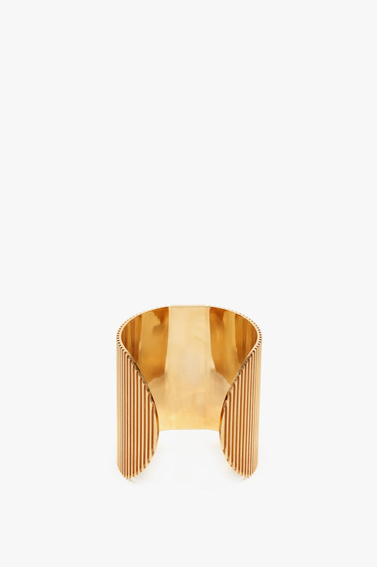 Exclusive Perfume Cuff In Gold cuff bracelet by Victoria Beckham with a polished finish and ribbed details on the sides, displayed against a white background.