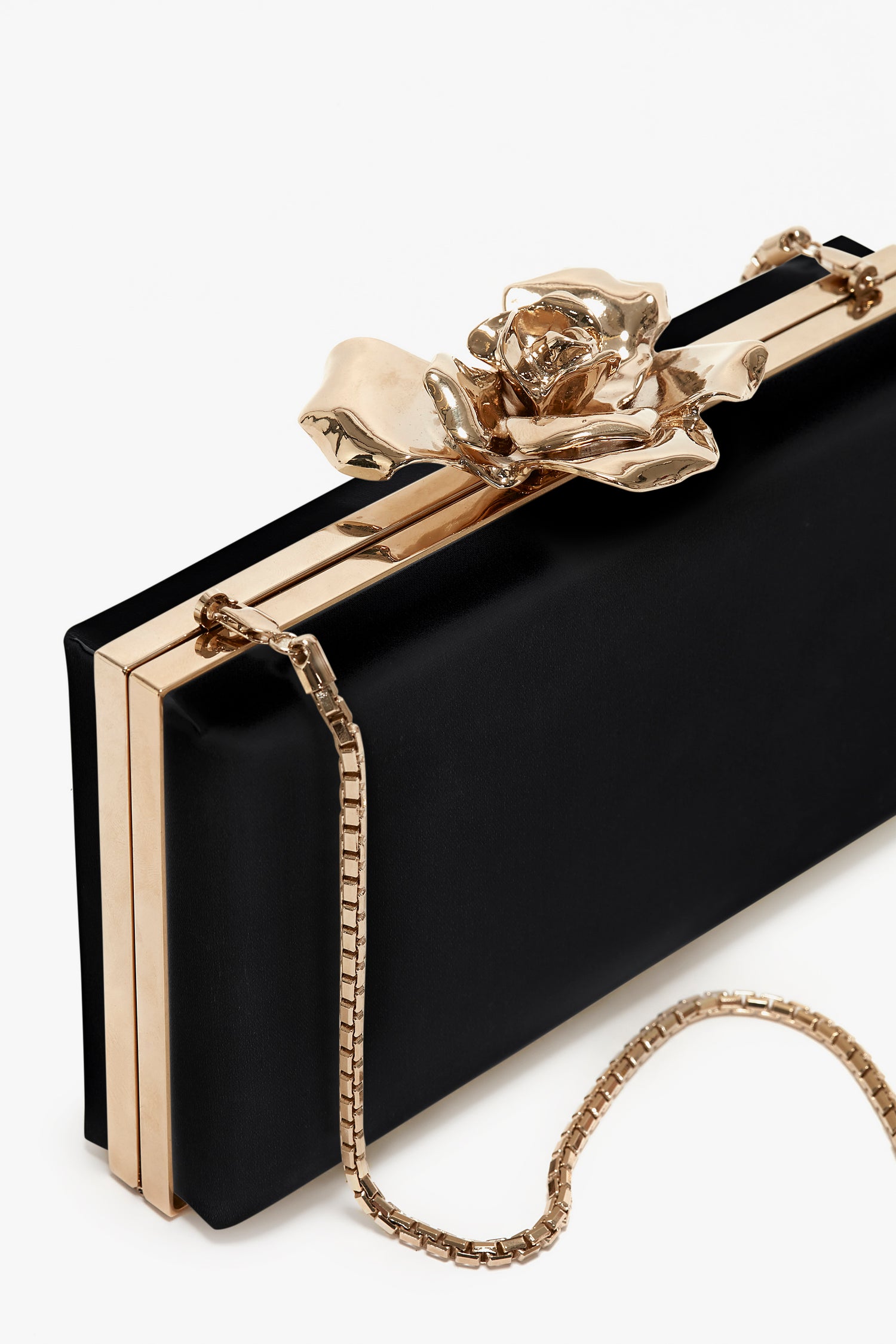 Elegant Victoria Beckham black Frame Flower Minaudiere clutch with gold trim and a flower clasp, featuring a chain strap, isolated on a white background.