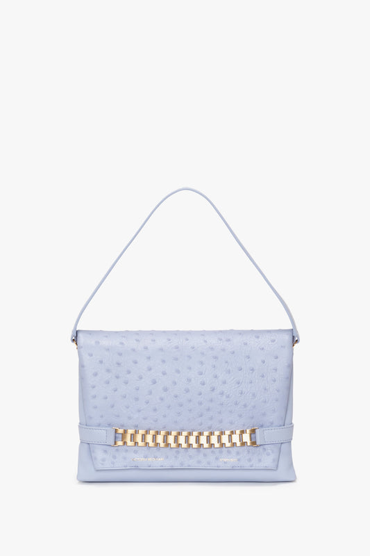 A Victoria Beckham light blue leather handbag with an embossed ostrich-effect surface and a gold metallic chain detail on the front, displayed against a white background.