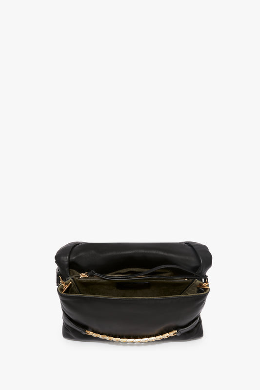 Victoria Beckham Puffy Chain Pouch With Strap In Black Leather with a gold chain strap and zipper, isolated on a white background.
