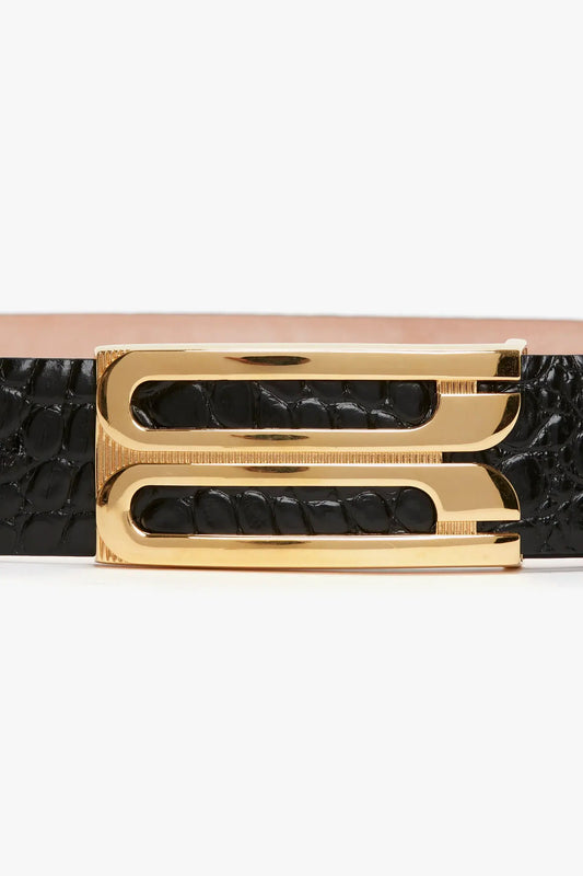Close-up view of a Victoria Beckham Jumbo Frame Belt In Black Croc-Effect Leather with shiny gold hardware on a white background.