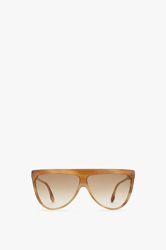 A pair of Victoria Beckham Classic Flat Top V Sunglasses in Honey Horn with a light brown frame and dark lenses, featuring luxurious horn-effect acetate, set against a plain white background.