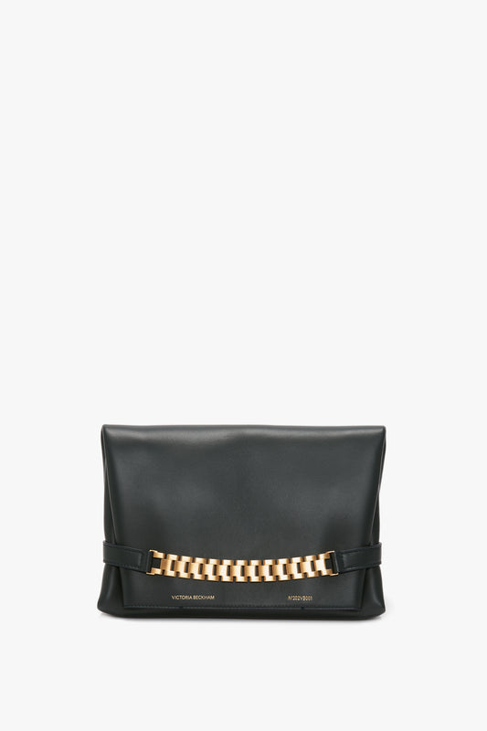 Chain Pouch Bag In Black Leather by Victoria Beckham with prominent gold-tone hardware across the front, displayed against a white background.