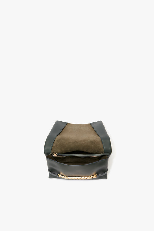 A Victoria Beckham black leather chain pouch bag with gold-tone hardware, isolated on a white background.