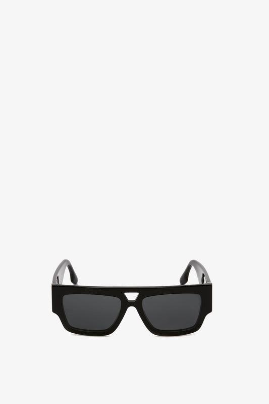 A pair of Victoria Beckham V Plaque Frame Sunglasses In Black with a sleek, modern design, isolated on a white background.