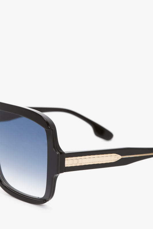 A pair of Victoria Beckham Layered Mask Sunglasses In Black Gradient with thick black frames and graduated black lenses, featuring intricate detailing on the arms, isolated on a white background.