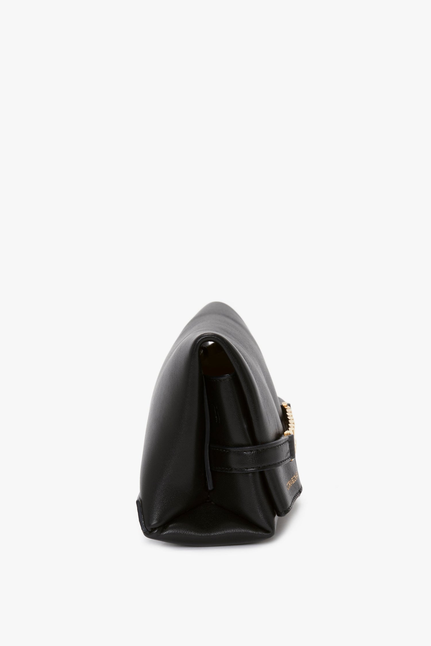 Side profile of a Victoria Beckham Mini Chain Pouch Bag With Long Strap In Black Leather with a visible gold clasp.