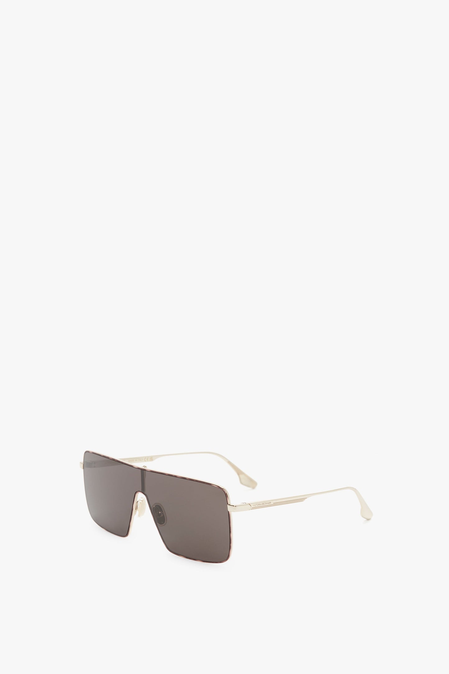 A pair of Rectangular Visor In Gold-Smoke Victoria Beckham sunglasses with dark lenses and thin, metallic temples shown against a white background.
