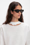 A person with long, dark hair wearing black rectangular Layered Lens Visor Sunglasses In Black from Victoria Beckham and a white shirt with a label on the collar.