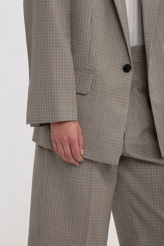 Close-up of a person wearing the Victoria Beckham Peak Lapel Jacket In Multi and matching pants with a contemporary aesthetic; only the torso and part of the arm are visible.