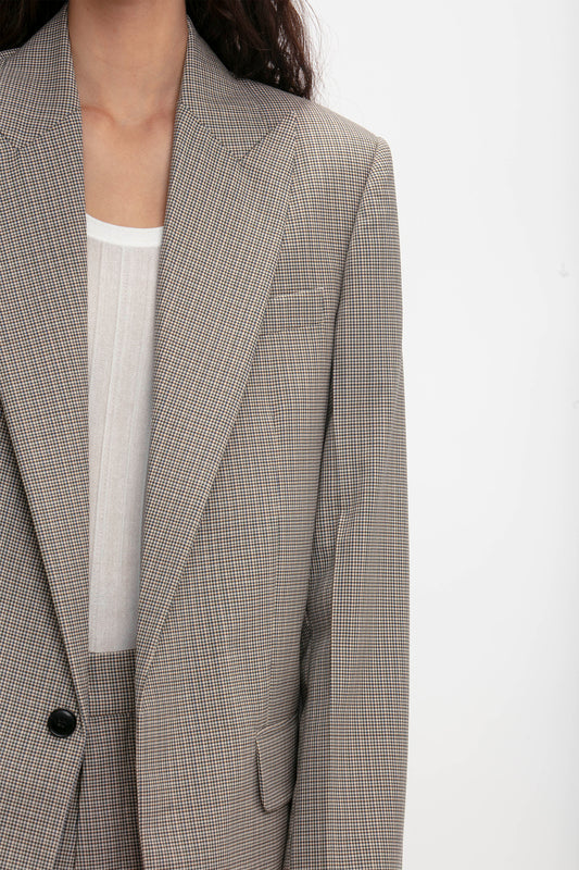 Close-up of a person wearing a grey tailored blazer over a white shirt, showcasing the contemporary aesthetic. The image highlights the upper half of the Peak Lapel Jacket In Multi by Victoria Beckham and part of the shirt, with the person's left arm partially visible.