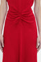 Close-up of a person wearing a red Exclusive Gathered Waist Midi Dress In Carmine by Victoria Beckham, with ruched detailing around the waist, arms resting by sides.