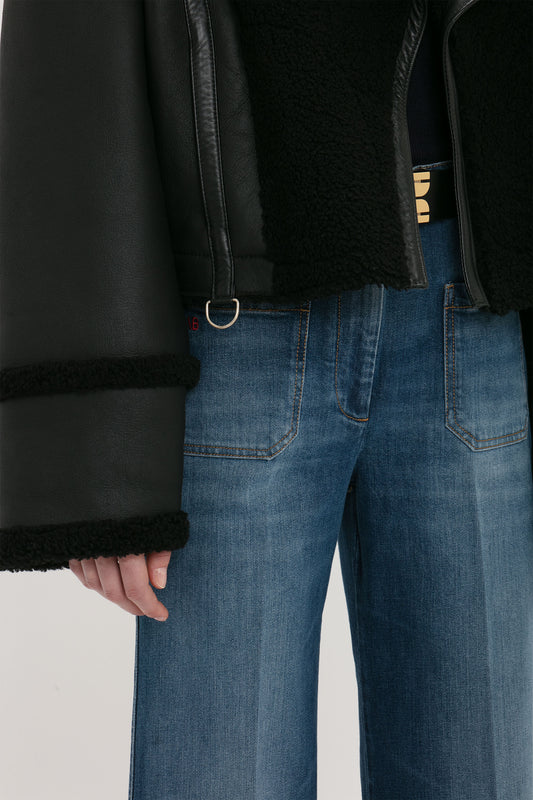 Person wearing a Victoria Beckham Shearling Jacket In Black and blue jeans. The photo is cropped to show only the torso and upper legs.
