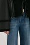 Person wearing a Victoria Beckham Shearling Jacket In Black and blue jeans. The photo is cropped to show only the torso and upper legs.