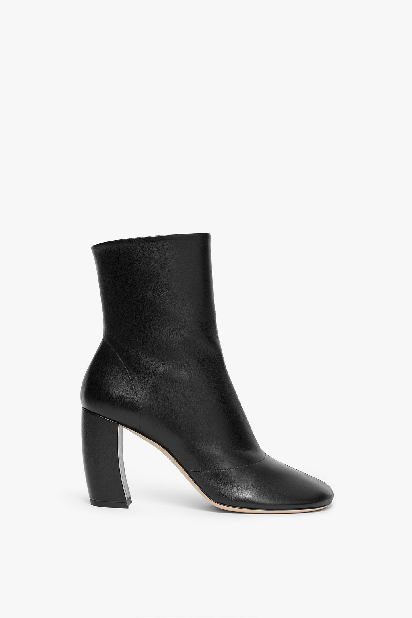 A Victoria Beckham Capri Ankle Boot 85mm in Black with a rounded toe and a high, thick heel, viewed from the side against a white background.