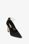 A single Pointy Toe Pump in Black Satin by Victoria Beckham, featuring a 100mm heel, a pointed toe, and an ankle strap adorned with a gold hoop detail.