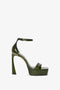 A Victoria Beckham Squared Toe Platform Sandal in Green Grained Patent with an ankle strap and buckle, featuring a sleek, glossy finish and a squared toe. This 100mm heel adds both height and style.