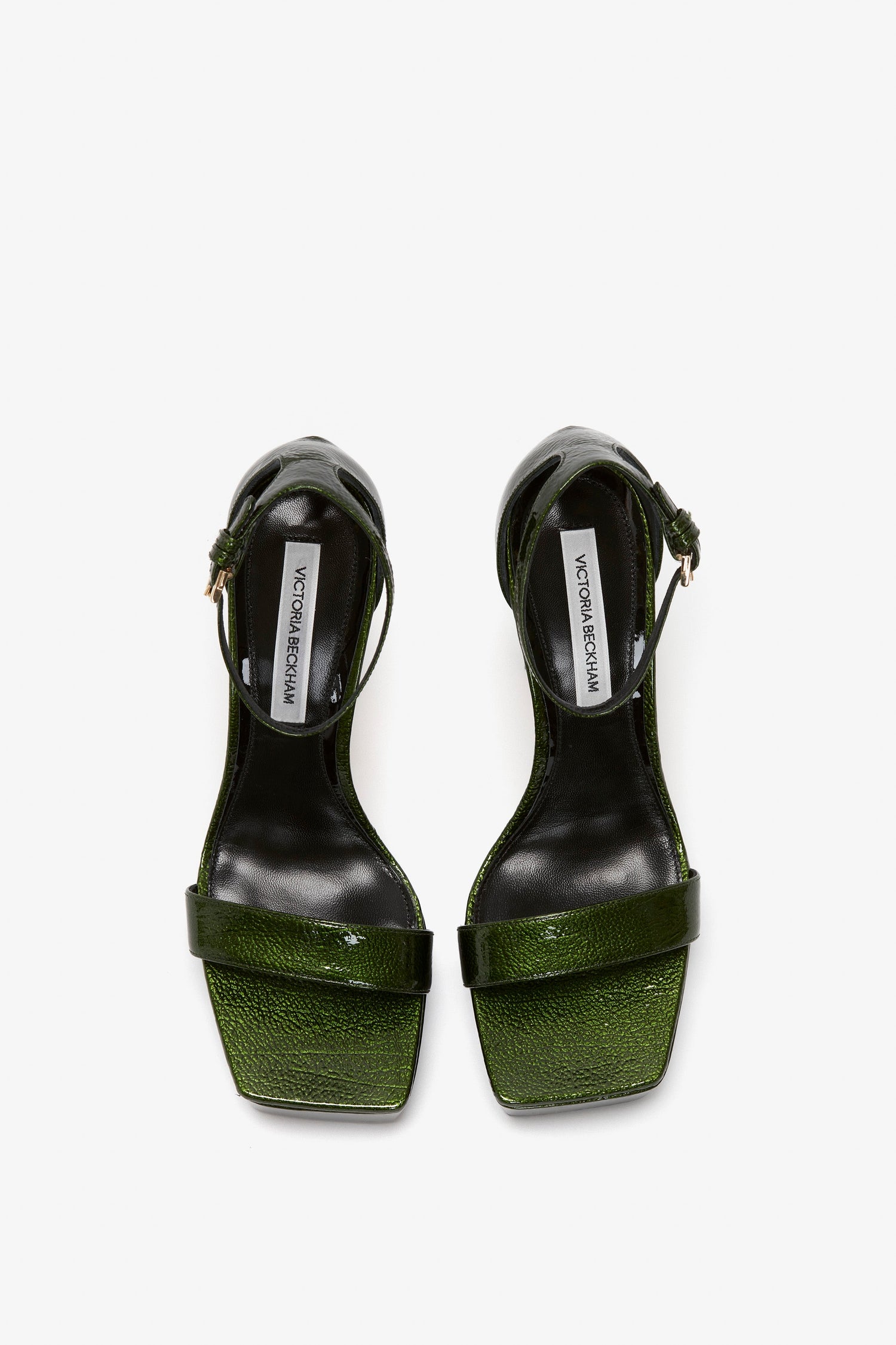 A pair of Squared Toe Platform Sandals in Green Grained Patent with ankle straps and a label reading "Victoria Beckham" on the insoles, featuring a stylish 100mm heel.