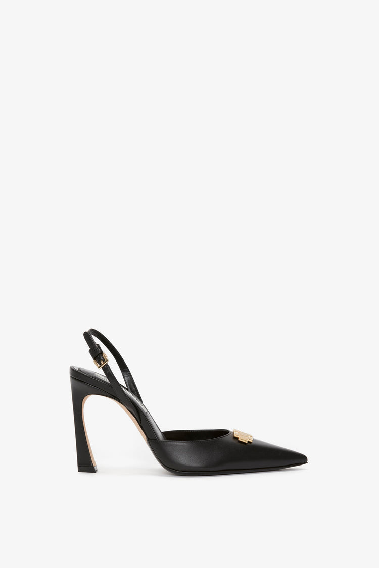 A black **Pointy Toe Sling Back in Black Calf** with a gold buckle and chain detail, featuring a pointed toe and a stiletto heel, by **Victoria Beckham**.