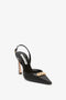 A Pointy Toe Sling back in Black Calf by Victoria Beckham with a chain detail on the front and an ankle strap with a buckle.