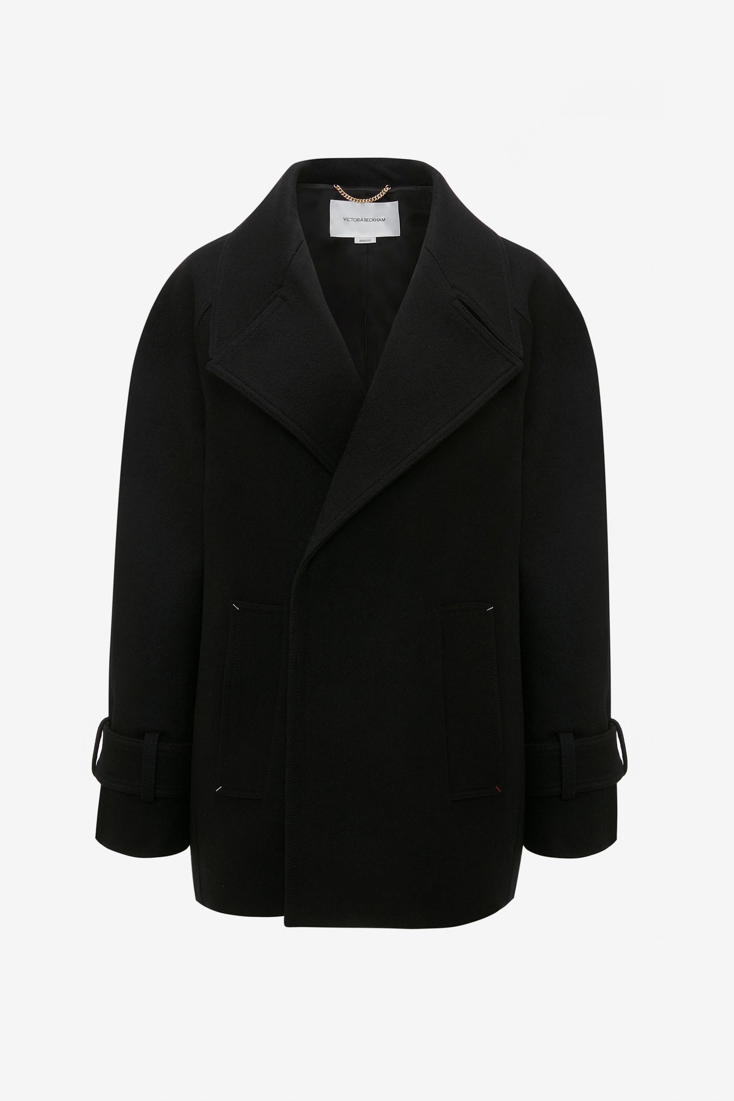 Black, long-sleeve double-breasted oversized pea coat with wide lapels, front pockets, and buckled straps on the cuffs, made from luxurious melton wool. The Victoria Beckham Oversized Pea Coat In Black hangs elegantly on an invisible hanger against a plain white background, showcasing its impeccable masculine tailoring.