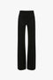 The Victoria Beckham Alina Tailored Trouser In Black features a super-high waist with flared legs, showcasing a back view complete with two pockets and belt loops.