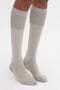 Person wearing a pair of Victoria Beckham Superfine Rib Socks In Lunar Grey and Sesame made from 100% cotton.