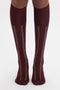 Person sporting Victoria Beckham Superfine Rib Socks In Burgundy with a burgundy and white design on a plain white background.